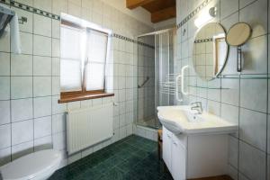 ein weißes Badezimmer mit einem Waschbecken und einem Spiegel in der Unterkunft Weingut Kögl in Ratsch an der Weinstraße