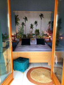 a bedroom with a bed with palm trees on the wall at Maison d'une chambre avec jardin et wifi a Lectoure a 4 km de la plage in Lectoure
