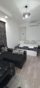 sala de estar con 2 camas y sofá en Apartments Lezzet, en Tiflis