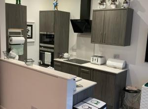 a kitchen with wooden cabinets and a counter top at The Monroe - 2nd Floor - Luxury for up to 4 guests near Open Air Theatre and North Bay in Scarborough