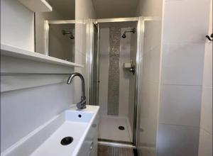 a white bathroom with a shower and a sink at En-suite near everything. Shepherd's Bush - London in London