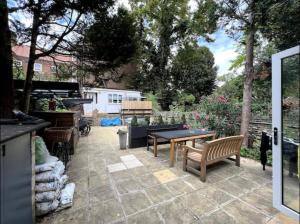 a patio with benches and a table and a grill at En-suite near everything. Shepherd's Bush - London in London