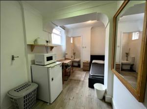 a small room with a kitchen and a microwave at En-suite near everything. Shepherd's Bush - London in London