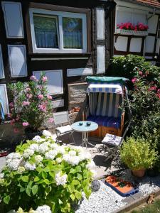 a patio with a chair and flowers in front of a house at Perle im Zentrum in Eschwege