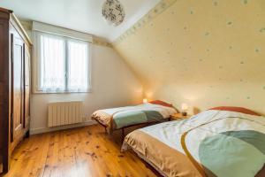 1 dormitorio con 2 camas y ventana en La Maison Bretonne - 300m de la mer, en Pleubian