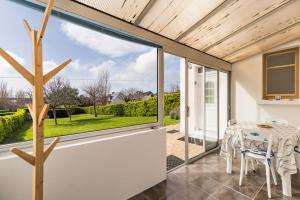 una extensión de cristal a una casa con mesa de comedor en La Maison Bretonne - 300m de la mer, en Pleubian