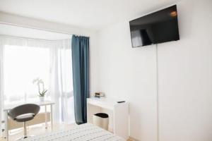 a bedroom with a bed and a television on the wall at Swetis Passage in Pulheim