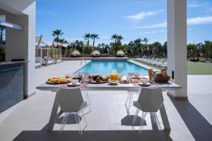 a table with food on it next to a swimming pool at Es Maiols Casa B in Can Furnet