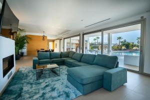 a living room with a blue couch and a tv at Es Maiols Casa B in Can Furnet