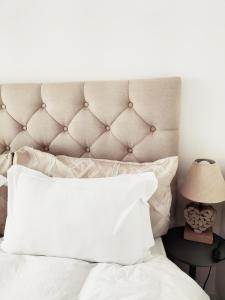 a bedroom with a white bed with a large headboard at la sardine dorée in Sangatte