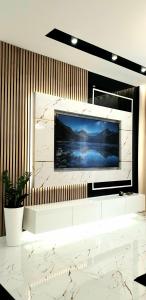 Elle comprend une grande télévision murale à écran plat. dans l'établissement VIP Room 2+2, à Konin