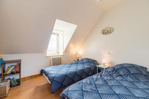 a bedroom with two beds and a window at La Maison Bleue - 300m de la mer in Pleubian