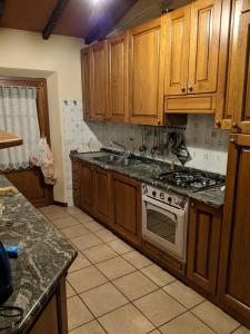 uma cozinha com armários de madeira e um forno com placa de fogão em La Rosetta em Querceta