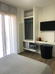 una camera con letto, TV e finestra di Relax & Emozioni Rooms a Valeggio sul Mincio