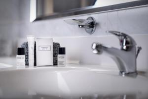 a bathroom sink withbranded products sitting on it at Cosmopolitan Bobycentrum - Czech Leading Hotels in Brno