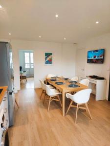 comedor con mesa de madera y sillas blancas en Lumineux 2 Chambres avec Garage privé - Tram à 1 min en Grenoble