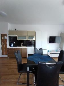 ein Wohnzimmer mit einem Tisch und Stühlen sowie eine Küche in der Unterkunft Flamingo 20 in Misdroy