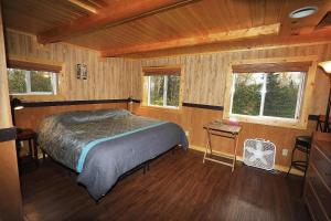 a bedroom with a bed in a wooden cabin at Denali Park View Family Log Cabin in Healy