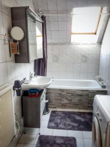 ein Badezimmer mit einem Waschbecken und einer Badewanne in der Unterkunft Ferienwohnung Klagenfurt in Klagenfurt am Wörthersee