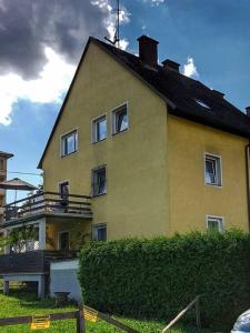 ein großes gelbes Haus mit Dach in der Unterkunft Ferienwohnung Klagenfurt in Klagenfurt am Wörthersee