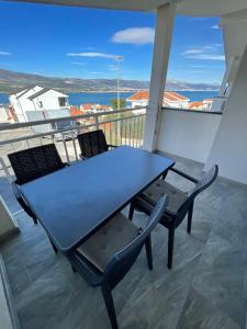 a table and chairs on a balcony with a view of the ocean at Apartments Holiday Gavric in Trogir