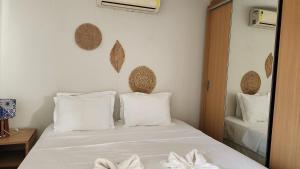 1 dormitorio con 1 cama con sábanas blancas y espejo en Beachfront Apartment, en Cumbuco