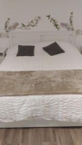 ein weißes Bett mit schwarzen Kissen darauf in der Unterkunft Vatican's apartment in Rom