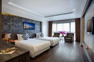 um quarto de hotel com duas camas e uma televisão em My Linh Hotel em Hanói
