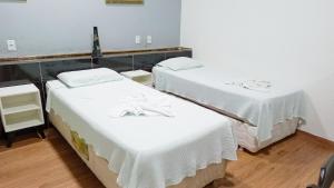 two beds in a hospital room with white sheets at Mindú Park Hotel in Manaus