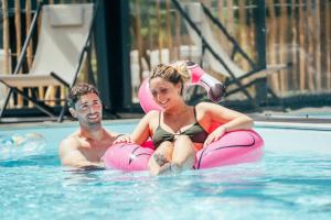a man and a woman sitting in a swimming pool at Holiday Inn - Bordeaux-Merignac by IHG in Mérignac