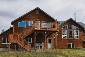 a large wooden house with a deck on it at 2 King Bedrooms each with full bath, Amazing Views! in Healy