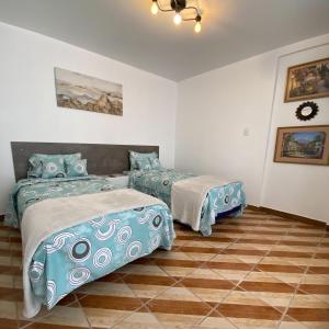 1 dormitorio con 2 camas y suelo de baldosa en Casa Balthazar Hostel, en Quito