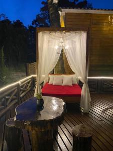 a bed on a deck with a canopy at Chale Sobre Rodas e Spa Exclusive - Localizado Próximo do Centro in Canela