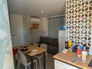 ラ・ガルド・フレネにあるMobil home yves et magaliのキッチン、リビングルーム(テーブル、ソファ付)