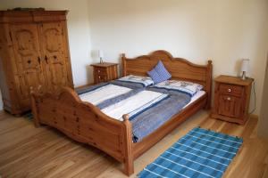 um quarto com uma cama de madeira e duas mesas de cabeceira em Ferienhaus Plöckenstein em Schwarzenberg am Bohmerwald