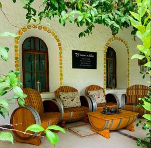 ein Zimmer mit Stühlen und einem Tisch vor einem Gebäude in der Unterkunft Casa de Coria in Chacras de Coria