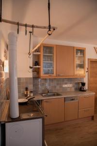 uma cozinha com armários de madeira e um lavatório em Ferienhaus Plöckenstein em Schwarzenberg am Bohmerwald