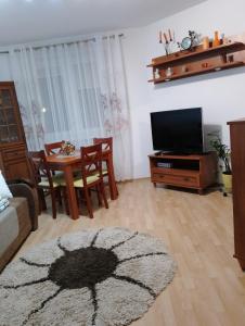 a living room with a couch and a tv and a table at Mieszkanie Jadwigi in Giżycko