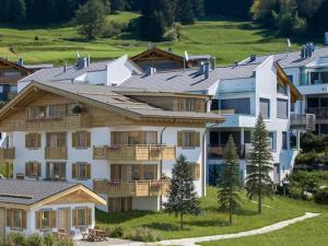 a large white building with a roof on a hill at Curvér 3002 Ir Apart Irene in Lenz