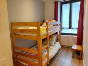 Ce dortoir comprend 2 lits superposés et une fenêtre. dans l'établissement Logement tout confort au coeur de la Haute-Savoie - Le Barycentre, à La Roche-sur-Foron