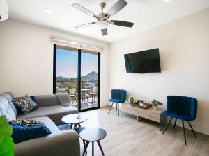 a living room with a couch and a flat screen tv at Sea Esta - Terra 194 in Cabo San Lucas