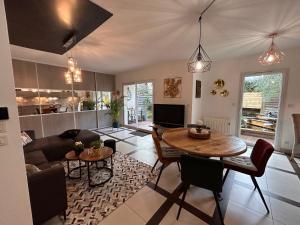 a living room with a table and a couch at Le Gahignon in Lanton