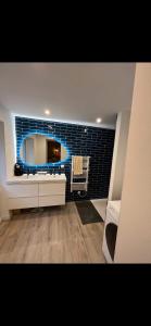 ein Badezimmer mit einem großen Spiegel und einem Waschbecken in der Unterkunft Maison de ville in Coulombs