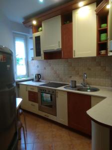 a kitchen with white cabinets and a stove top oven at Mieszkanie Jadwigi in Giżycko