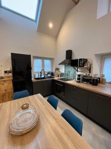 eine Küche mit einem Holztisch und blauen Stühlen in der Unterkunft Maison de ville in Coulombs