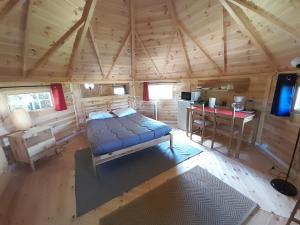 ein Schlafzimmer in einem Blockhaus mit einem Bett und einem Schreibtisch in der Unterkunft Chambre KOTA Insolite in Attigny