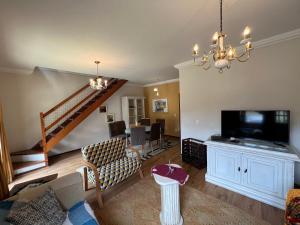 uma sala de estar com um sofá e uma televisão em Casa com vista deslumbrante próximo a feirinha em Teresópolis