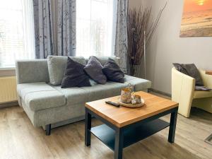 a living room with a couch and a coffee table at Gästehaus am Museumshafen in Carolinensiel