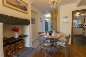 a dining room with a table and a fireplace at Holly Cottage in Bowness-on-Windermere