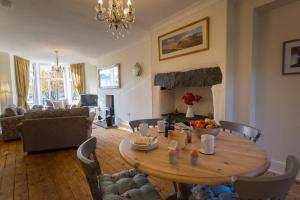 a living room with a wooden table with chairs and a living room at Holly Cottage in Bowness-on-Windermere